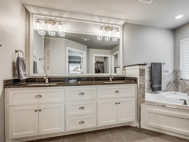 full bath featuring double vanity, visible vents, tile patterned floors, and a sink