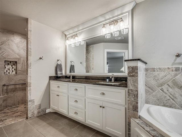 bathroom with a bath, double vanity, tile patterned flooring, and a sink