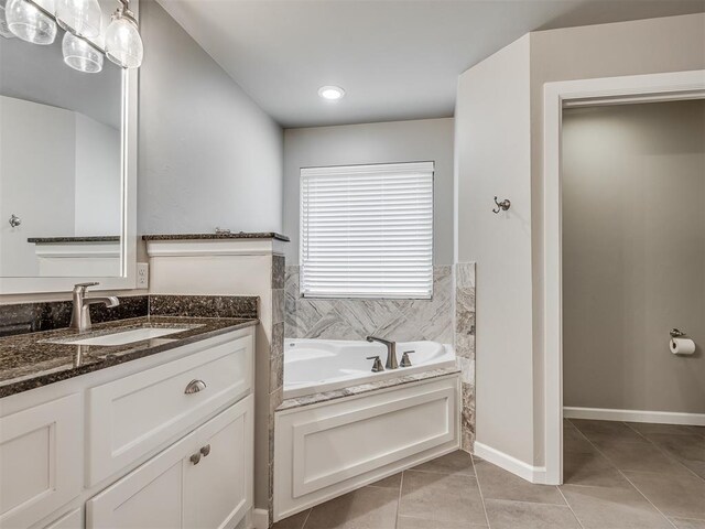 full bathroom featuring baseboards, a bath, tile patterned flooring, and vanity