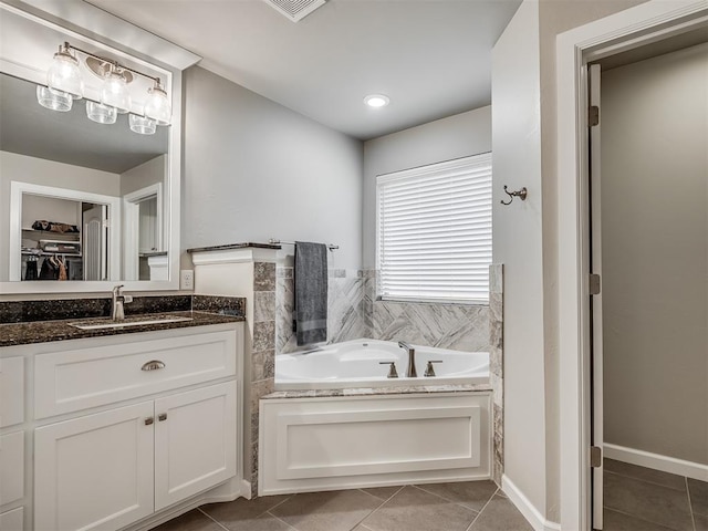 bathroom featuring a walk in closet, a bath, tile patterned flooring, and vanity