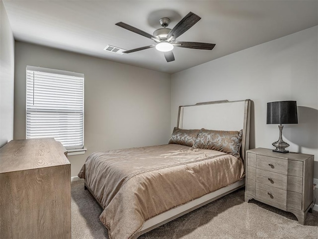 carpeted bedroom with visible vents, baseboards, and ceiling fan