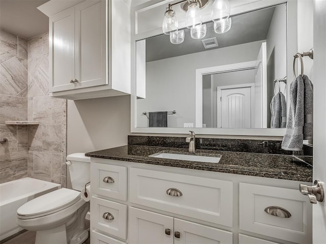bathroom featuring toilet, vanity, and visible vents