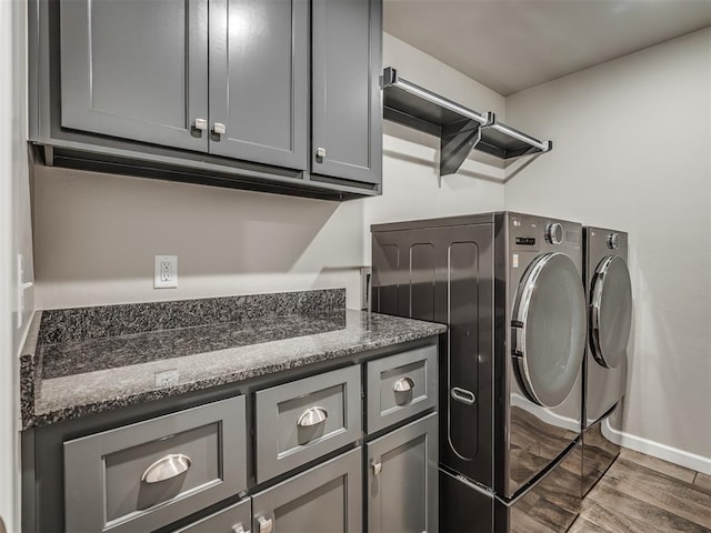 laundry room with washing machine and dryer, baseboards, and cabinet space