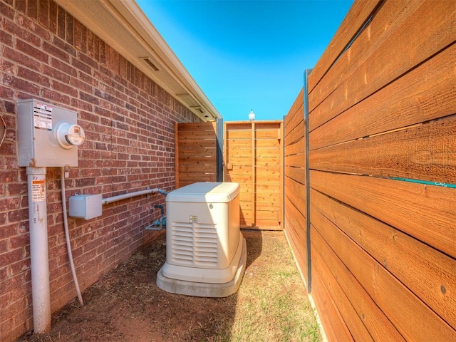 exterior details featuring brick siding, electric meter, and a power unit