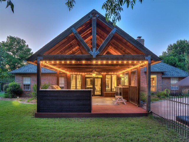 4216 Two Lakes Ave, Norman, OK 73072 - back of property with a wooden deck, a chimney, brick siding, and a ceiling fan