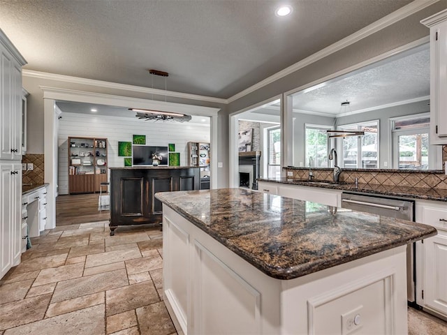 4216 Two Lakes Ave, Norman, OK 73072 - kitchen with tasteful backsplash, a textured ceiling, a kitchen island, dishwasher, and stone tile flooring