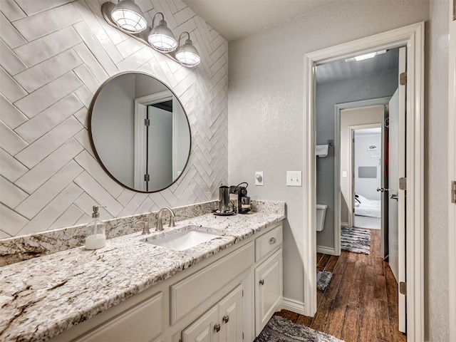 4216 Two Lakes Ave, Norman, OK 73072 - bathroom featuring vanity, wood finished floors, and a textured wall
