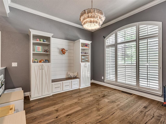 4216 Two Lakes Ave, Norman, OK 73072 - dining space with wood finished floors, a chandelier, crown molding, a textured ceiling, and a textured wall
