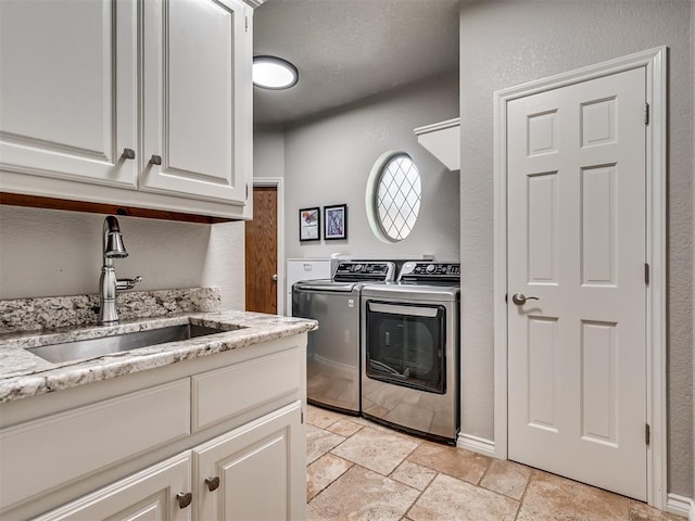 4216 Two Lakes Ave, Norman, OK 73072 - laundry area with washing machine and clothes dryer, stone tile flooring, cabinet space, and a textured wall