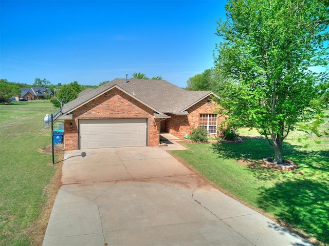 single story home with brick siding, an attached garage, a front yard, and concrete driveway