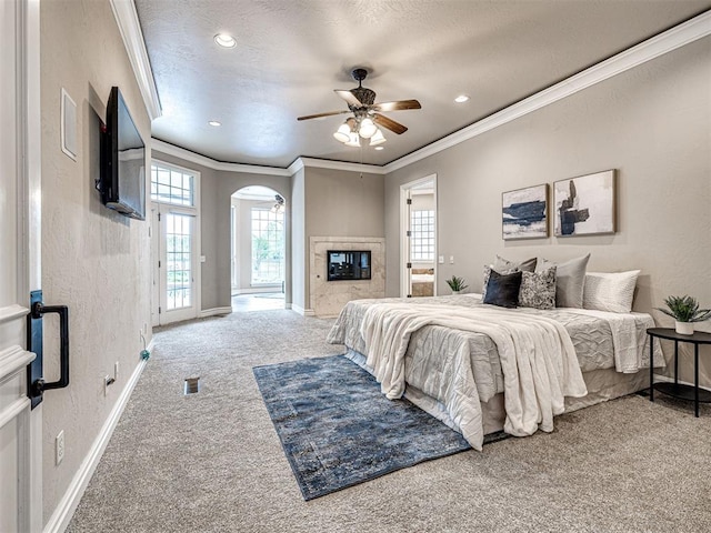 carpeted bedroom featuring crown molding, visible vents, baseboards, access to outside, and arched walkways