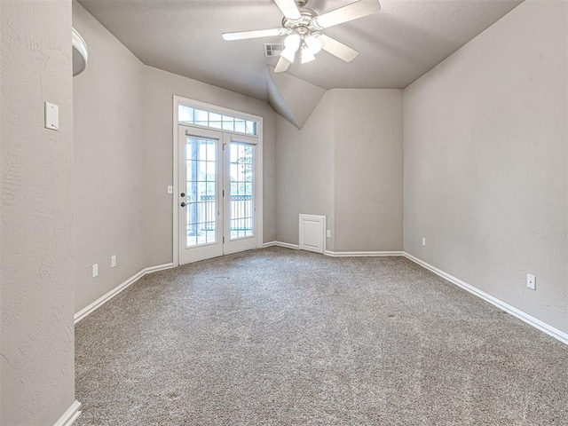 carpeted empty room with visible vents, a ceiling fan, baseboards, and lofted ceiling