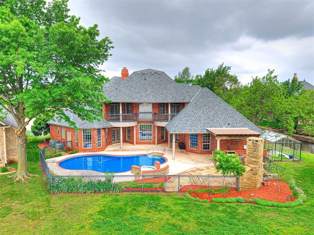 view of swimming pool featuring a lawn, fence, cooling unit, a fenced in pool, and a patio