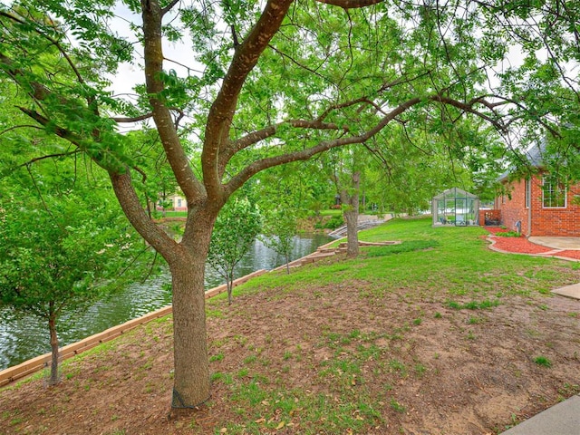 12505 Shire Ln, Oklahoma City, OK 73170 - view of yard featuring a greenhouse, a water view, and an outdoor structure
