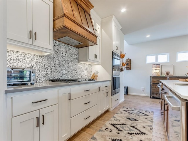 kitchen with custom exhaust hood, tasteful backsplash, a toaster, stainless steel appliances, and wine cooler