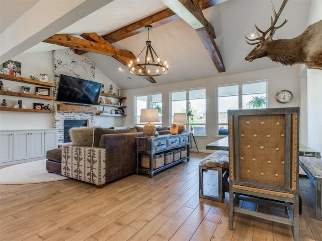 living area featuring a fireplace, beamed ceiling, a chandelier, light wood-style flooring, and high vaulted ceiling