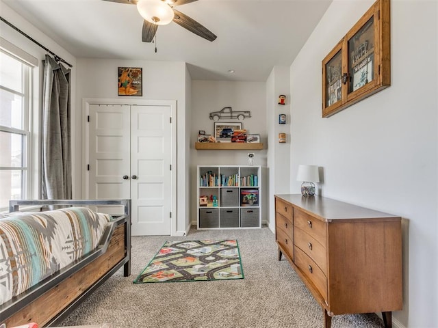 bedroom with ceiling fan, a closet, and light carpet