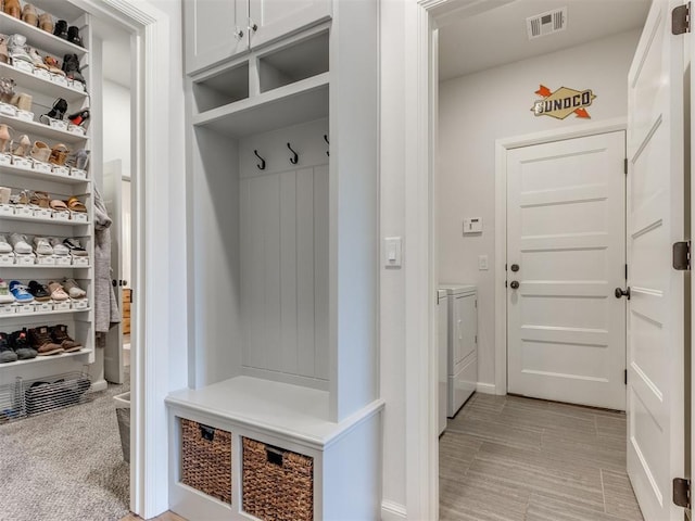 mudroom featuring separate washer and dryer, baseboards, and visible vents