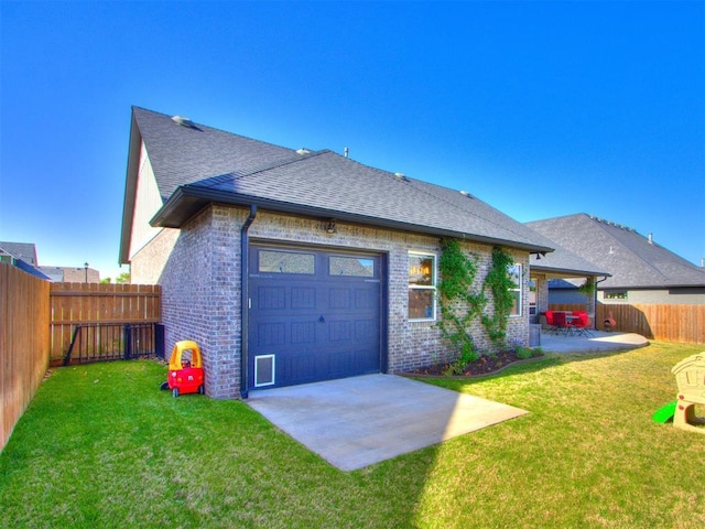 back of house featuring a lawn, an attached garage, brick siding, and a shingled roof
