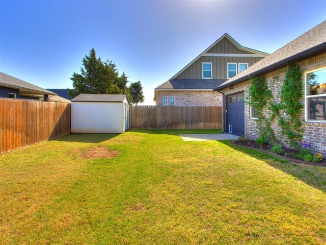 view of yard featuring a storage unit, an attached garage, an outbuilding, and a fenced backyard