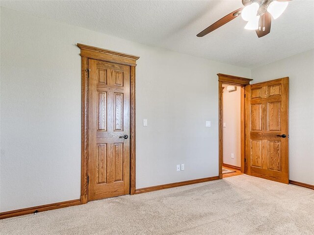 unfurnished bedroom with a ceiling fan, baseboards, and carpet