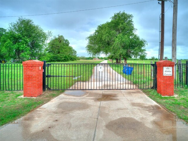 view of gate featuring fence and a yard