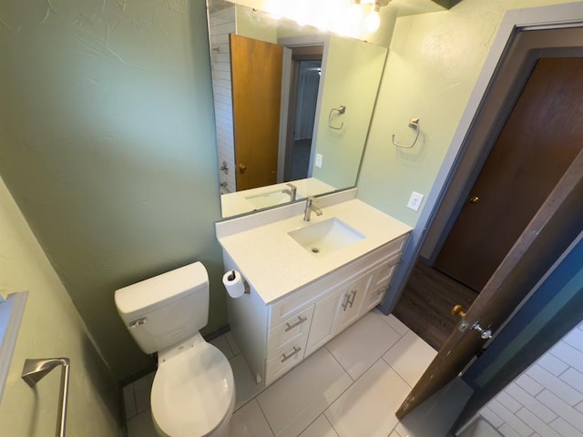 bathroom featuring vanity, tile patterned flooring, and toilet