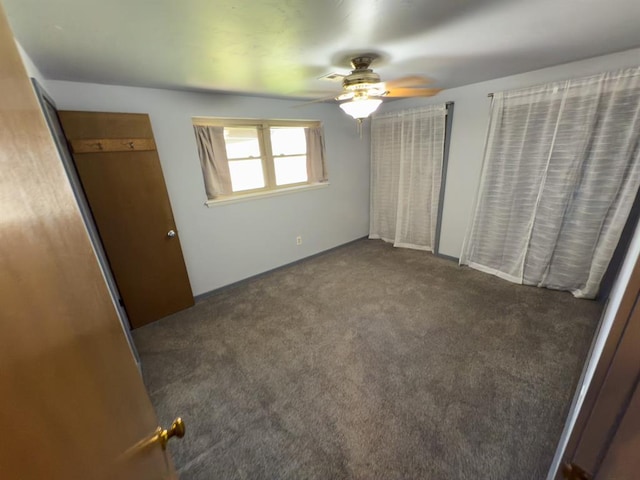 unfurnished bedroom featuring carpet floors, baseboards, and ceiling fan