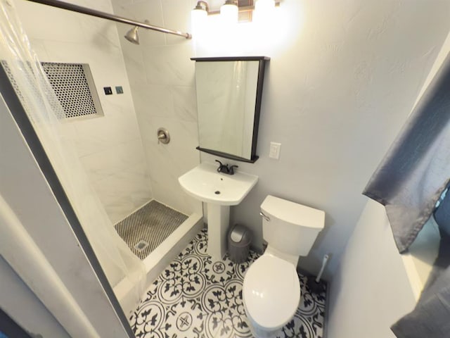 full bath with toilet, tile patterned flooring, and a stall shower