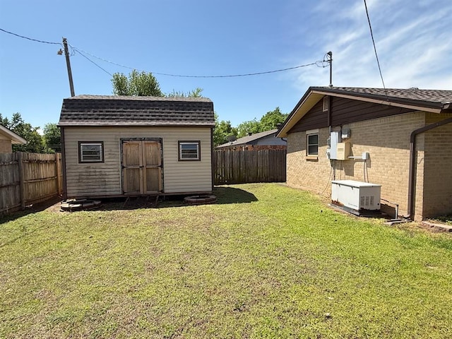 view of yard featuring a fenced backyard, an outdoor structure, and a storage shed