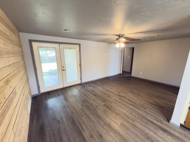 empty room featuring french doors, baseboards, visible vents, ceiling fan, and dark wood-type flooring