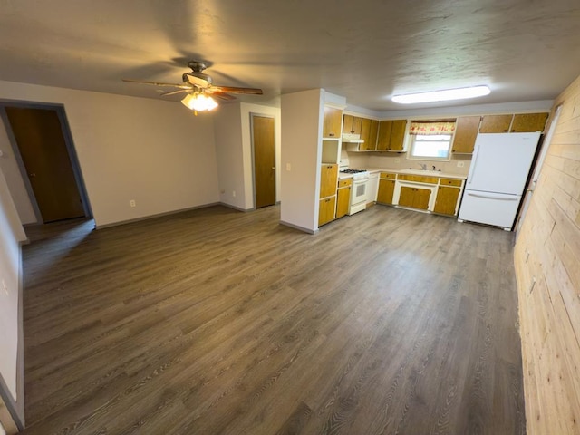 kitchen with dark wood finished floors, light countertops, a sink, white appliances, and ceiling fan