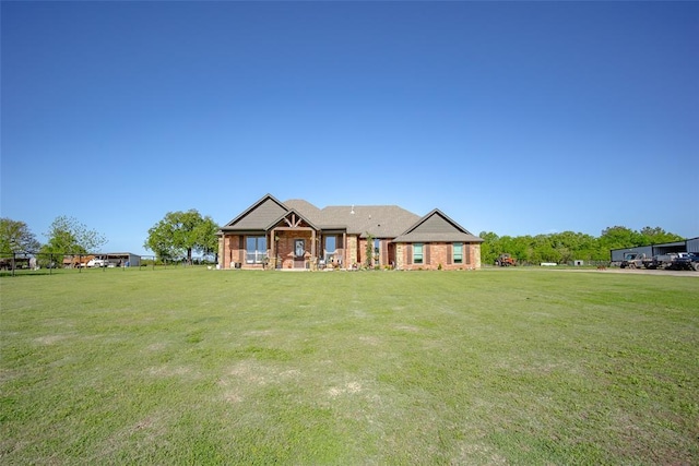 view of front of house featuring brick siding and a front yard