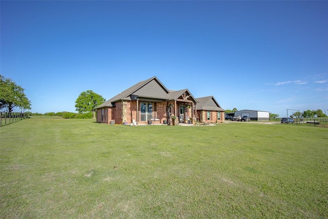 rear view of property with a yard, brick siding, fence, and a porch