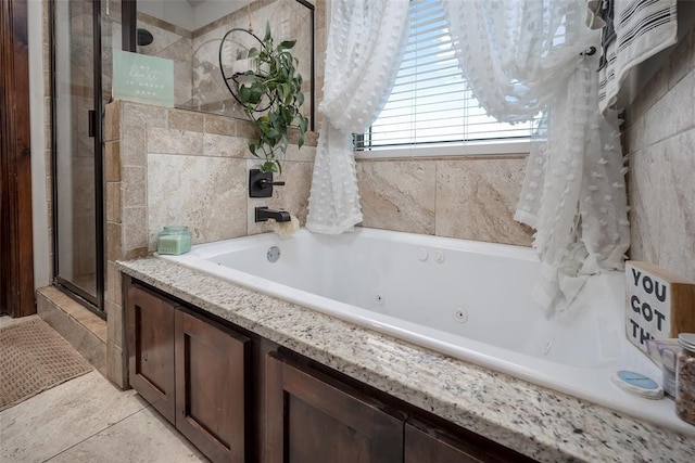 full bath featuring tile patterned flooring, a whirlpool tub, and a shower stall