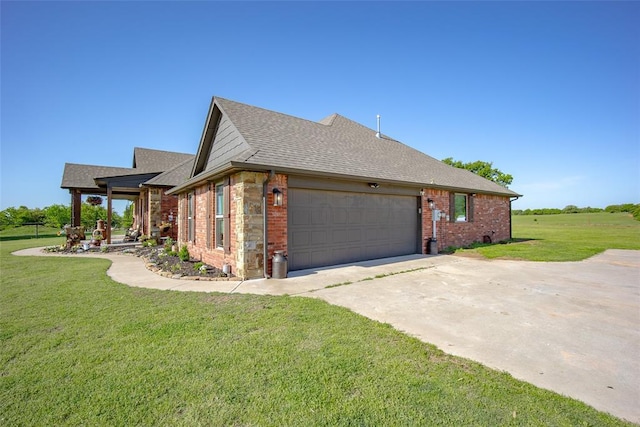 view of side of home featuring roof with shingles, brick siding, a garage, concrete driveway, and a lawn