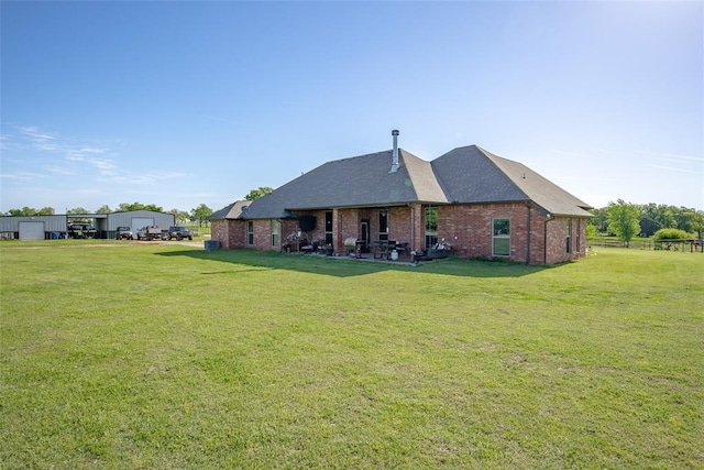 back of house with a yard and brick siding