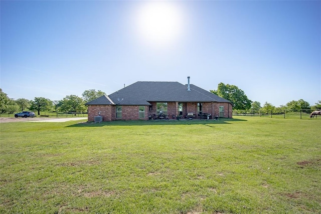 view of front of property with brick siding, fence, and a front yard