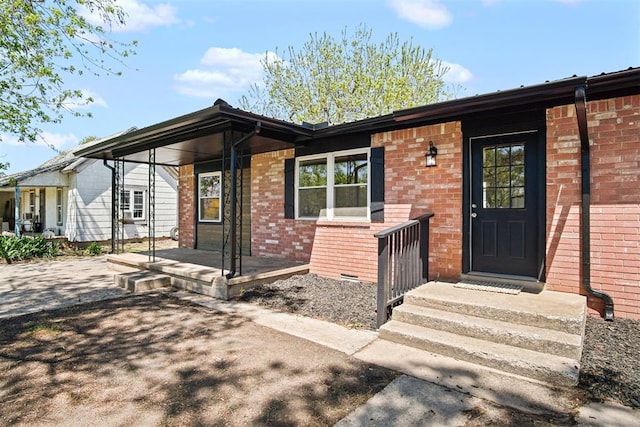 view of exterior entry with brick siding
