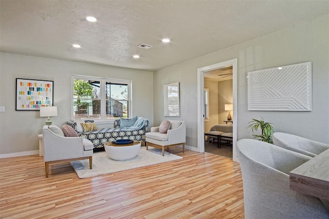 living area featuring baseboards, wood finished floors, visible vents, and recessed lighting