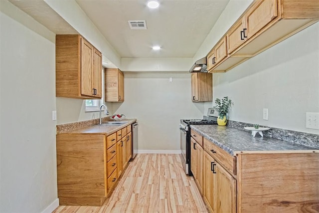 kitchen featuring a sink, light wood-style floors, baseboards, appliances with stainless steel finishes, and visible vents