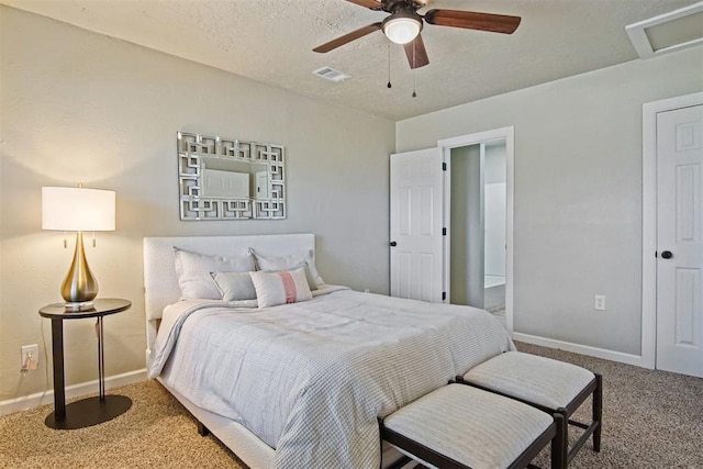 carpeted bedroom featuring attic access, baseboards, and a ceiling fan