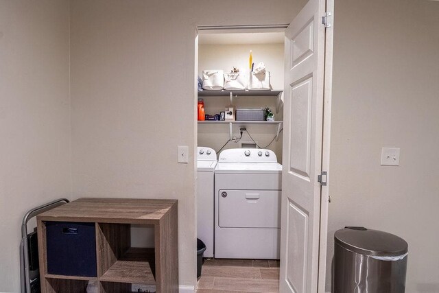 clothes washing area with laundry area, light wood-type flooring, and washing machine and clothes dryer