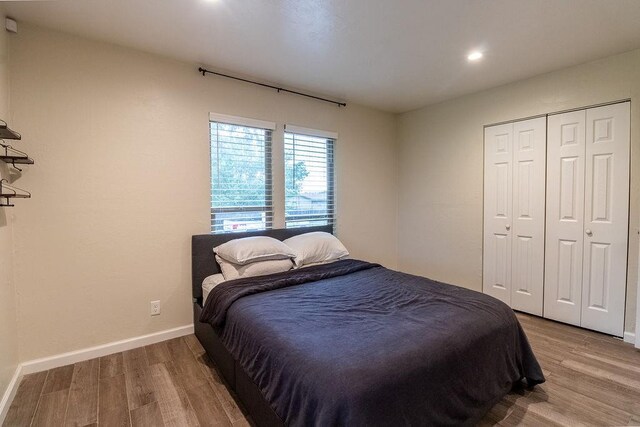 bedroom featuring baseboards, a closet, recessed lighting, and wood finished floors