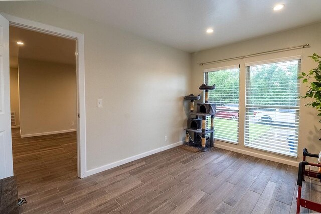 interior space with baseboards, recessed lighting, wood finished floors, and visible vents