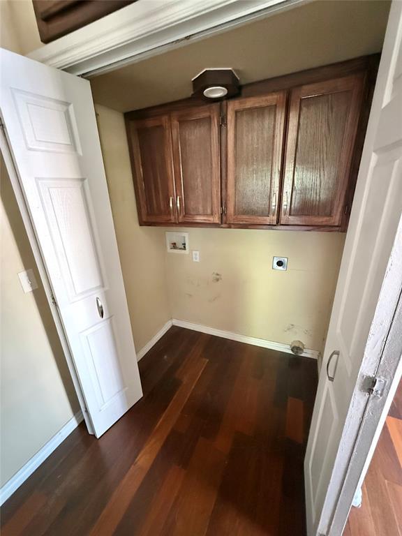 clothes washing area featuring dark wood-style floors, hookup for an electric dryer, baseboards, hookup for a washing machine, and cabinet space