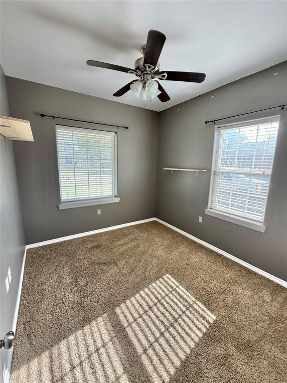 empty room with a ceiling fan, baseboards, and carpet floors