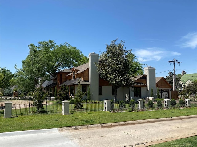 view of side of home with a lawn, a chimney, and a fenced front yard