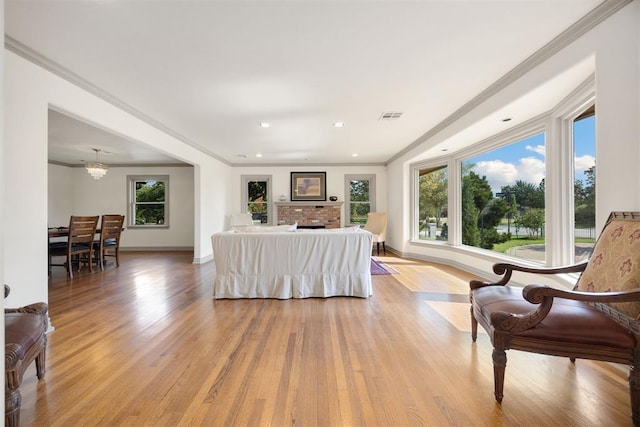 living room featuring baseboards, visible vents, recessed lighting, light wood-style floors, and ornamental molding