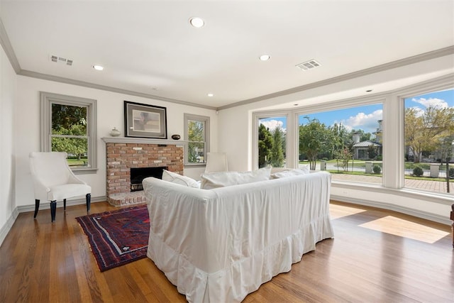 living room featuring wood finished floors, visible vents, and ornamental molding